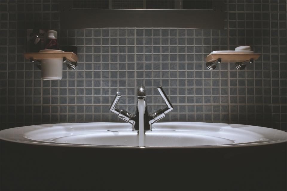 A modern bathroom basin with a chrome mixer tap