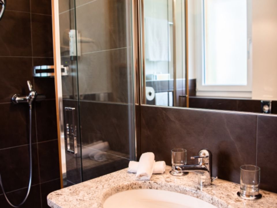 A walk-in glass shower and stone vanity