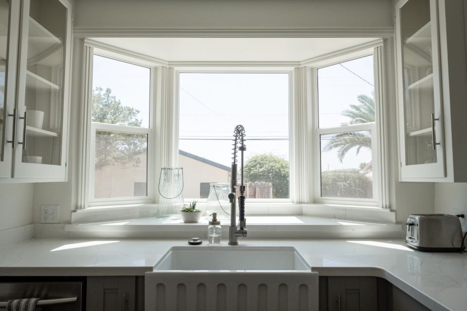 A farmhouse kitchen sink under a bay window